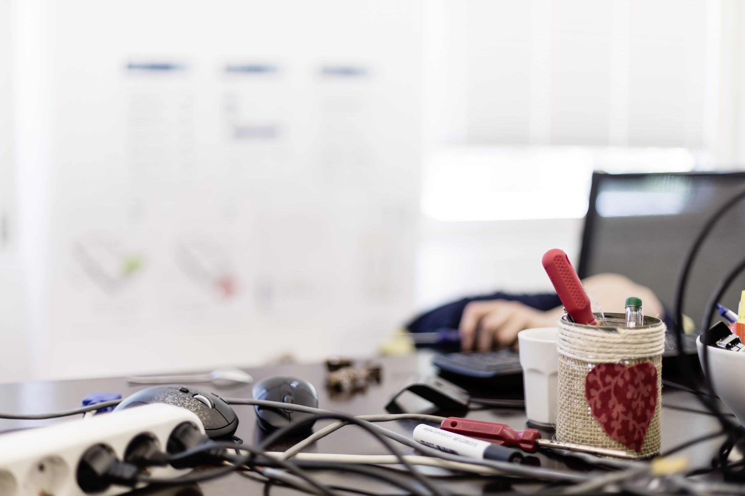 A laptop, a monitor and three pairs of sunglasses on a desk