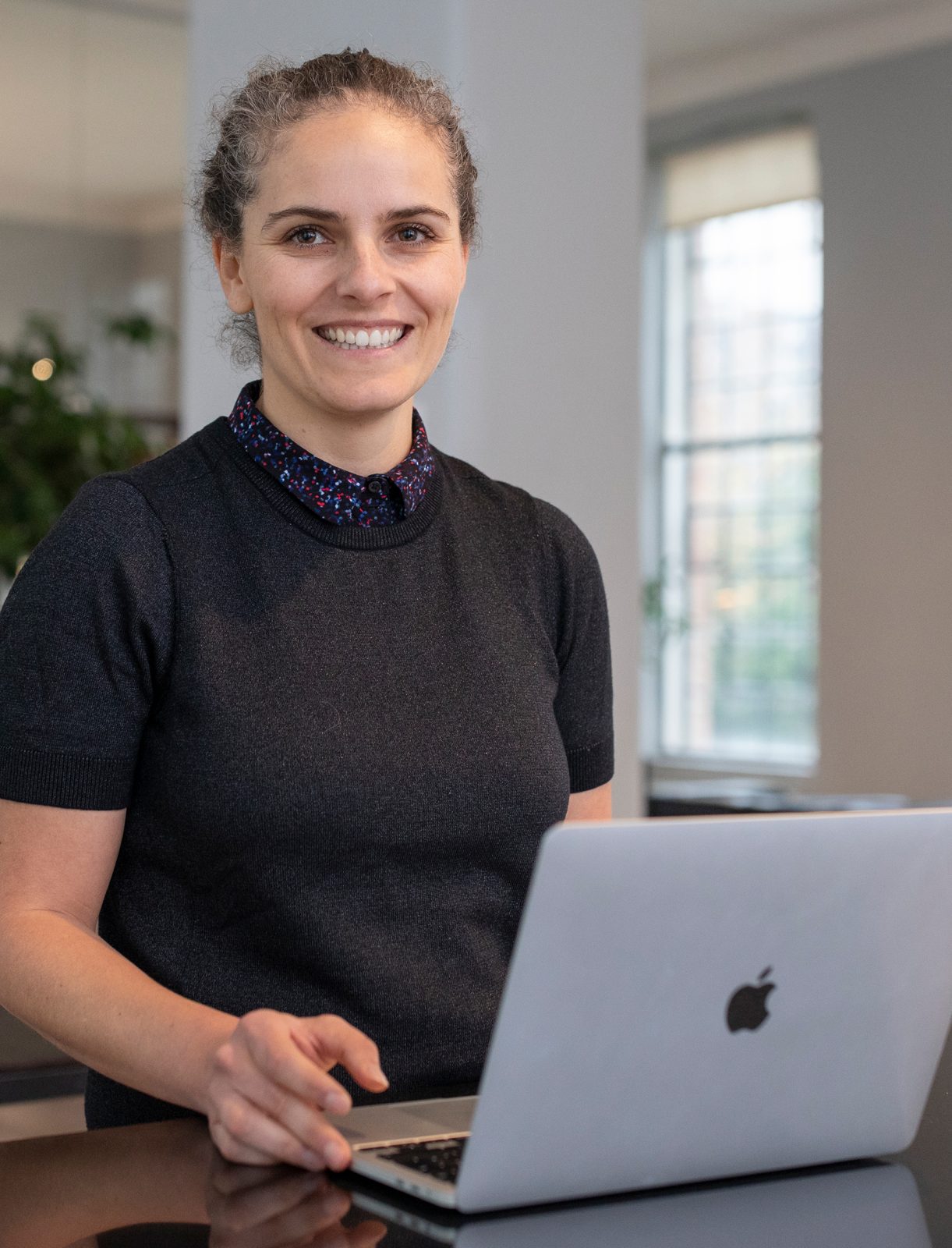 Ein Portrait von FONDA Mitarbeiterin Alexandra Haid vor ihrem Laptop
