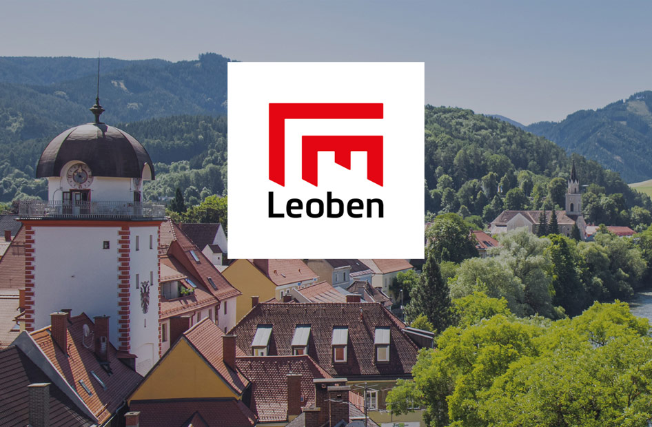 Logo der Stadt Leoben mit der Stadt Leoben und Bergen im Hintergrund