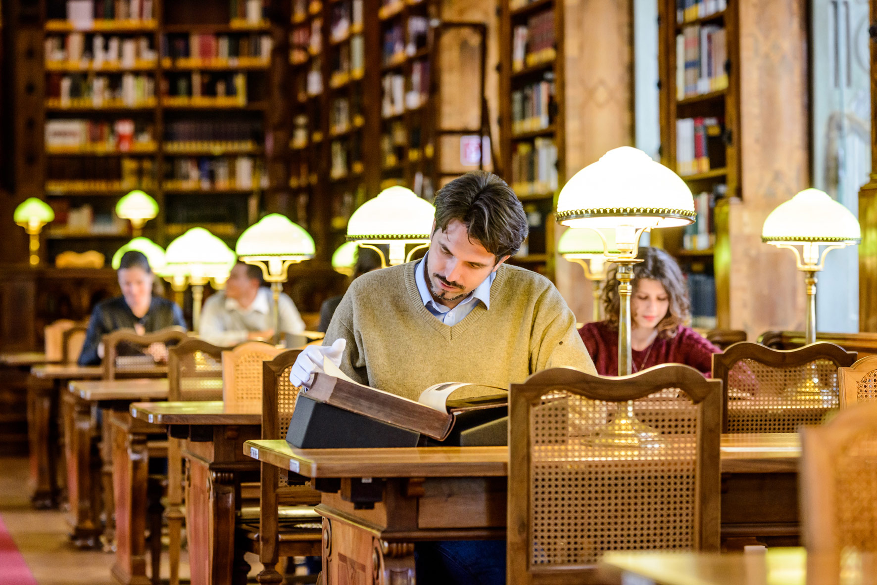 Ein Besucher liest ein Buch im Augustinerlesesaal der Österreichischen Nationalbibliothek