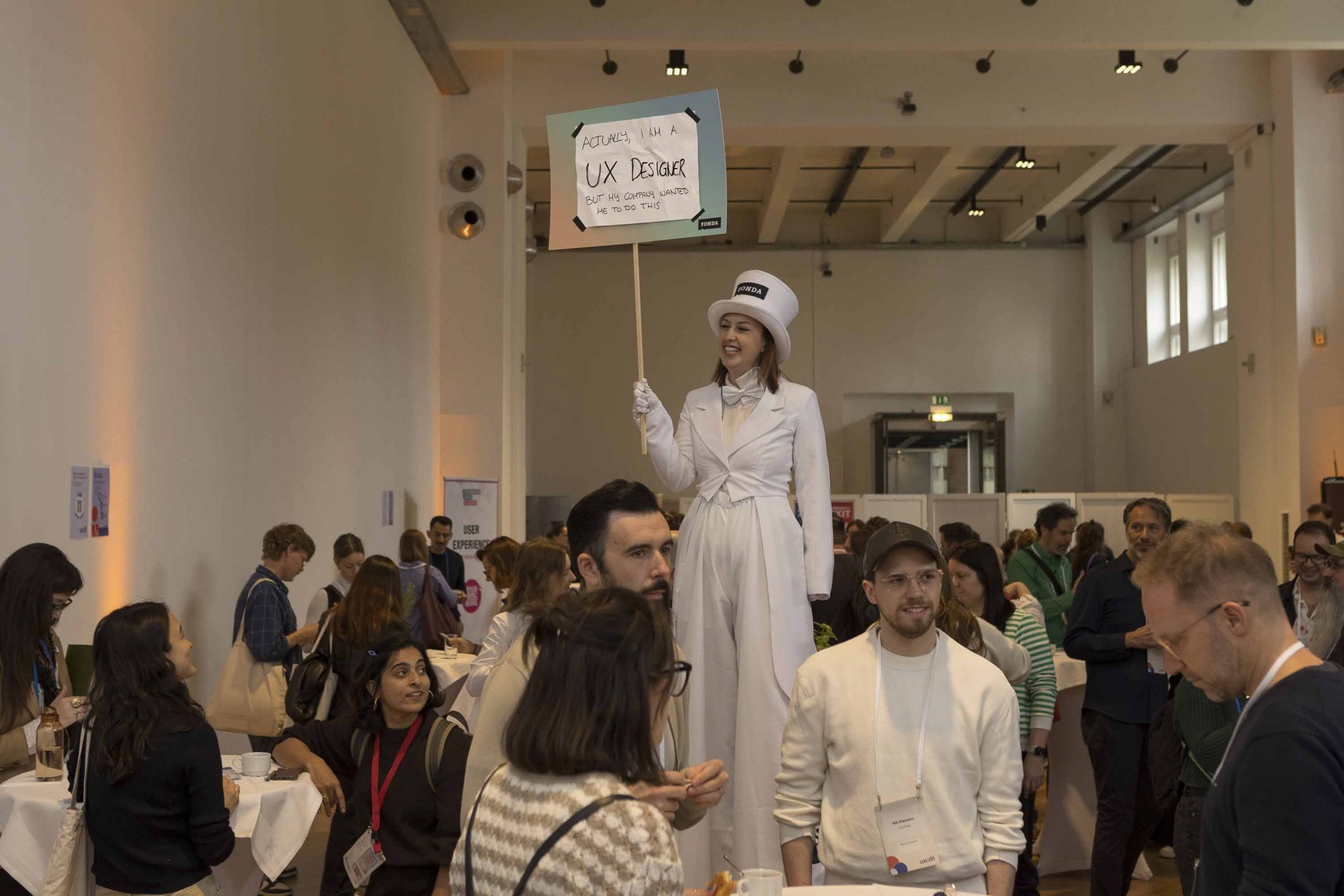 FONDA Stelzenläuferin mit einem Schild, auf dem steht 